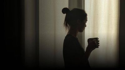 woman in a crowd with her hand raised